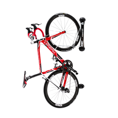 A black and red classic road bike rack with a fold-away designed rack, mounted on a surface.