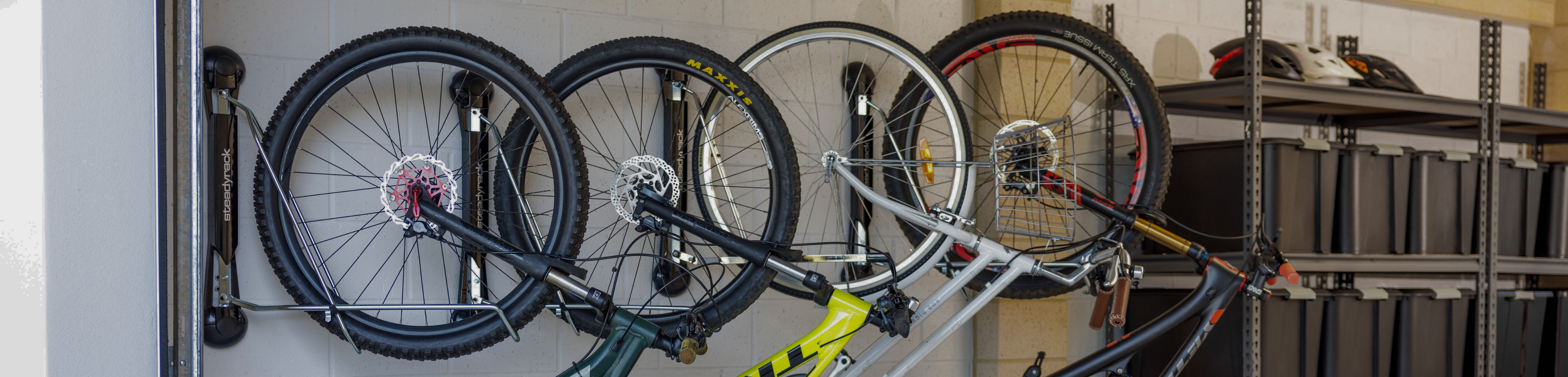 Four bikes in racks installed in a garage. 