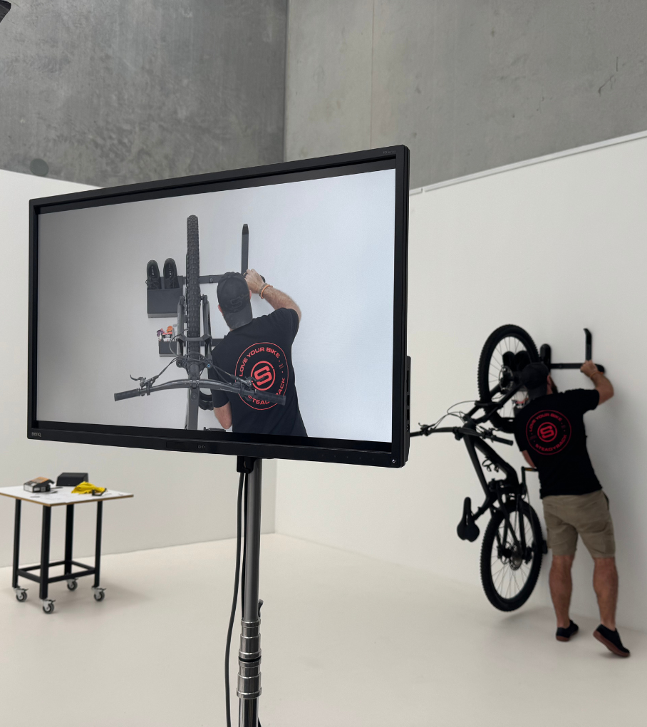 A film screen at a studio setting of a person adjusting a bike rack and GearMate storage system. 